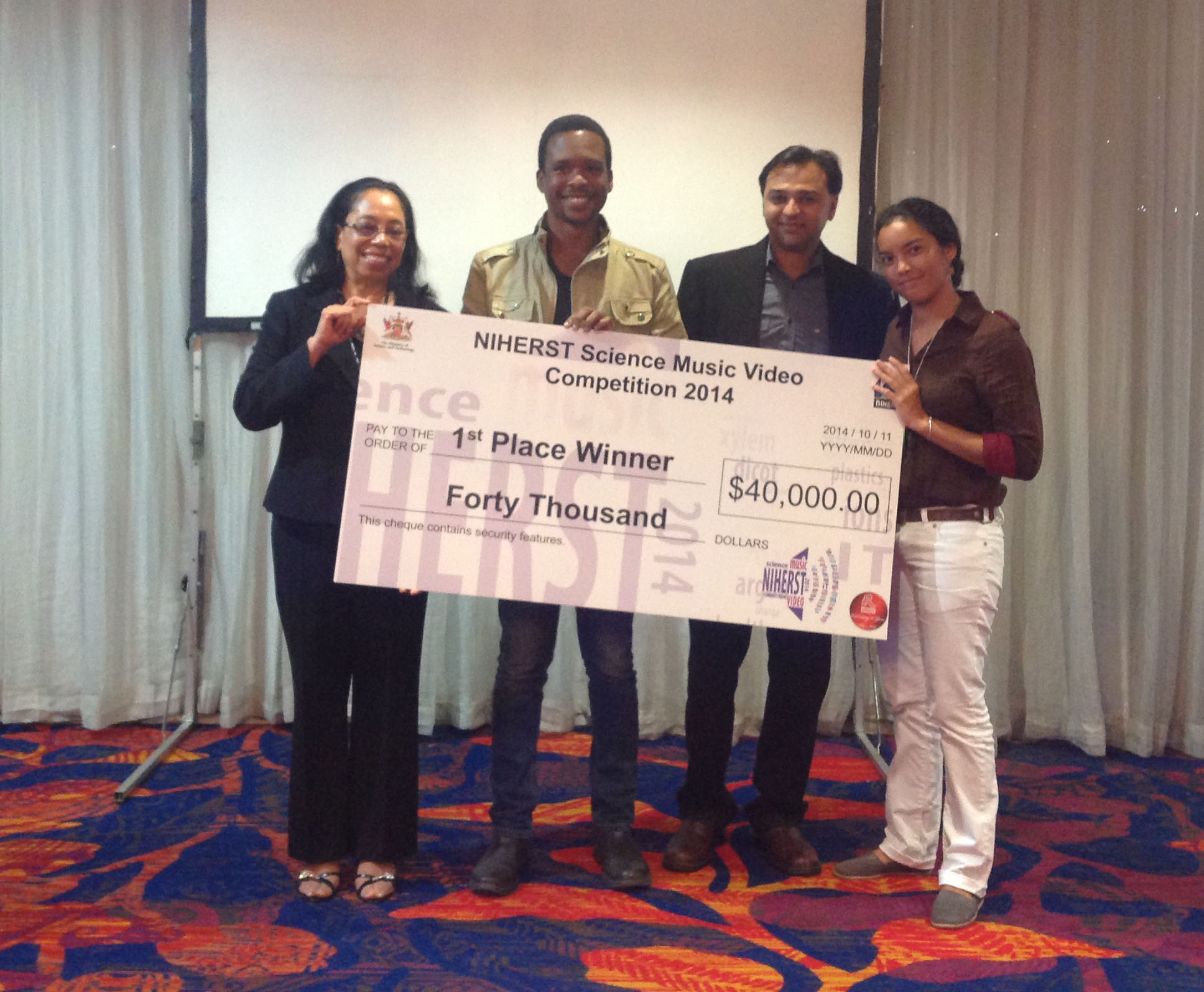 NIHERST presents the first place winners with their prize. (From left): Acting President of NIHERST, Joycelyn Lee Young; Joshua Cazoe; NIHERST Board member, Andre Thompson; and Tikira Beresford